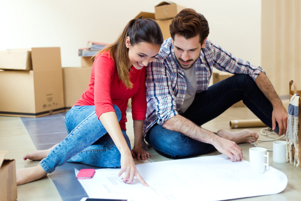 Jeune couple etudiant les plans de leur projet de renovation maison