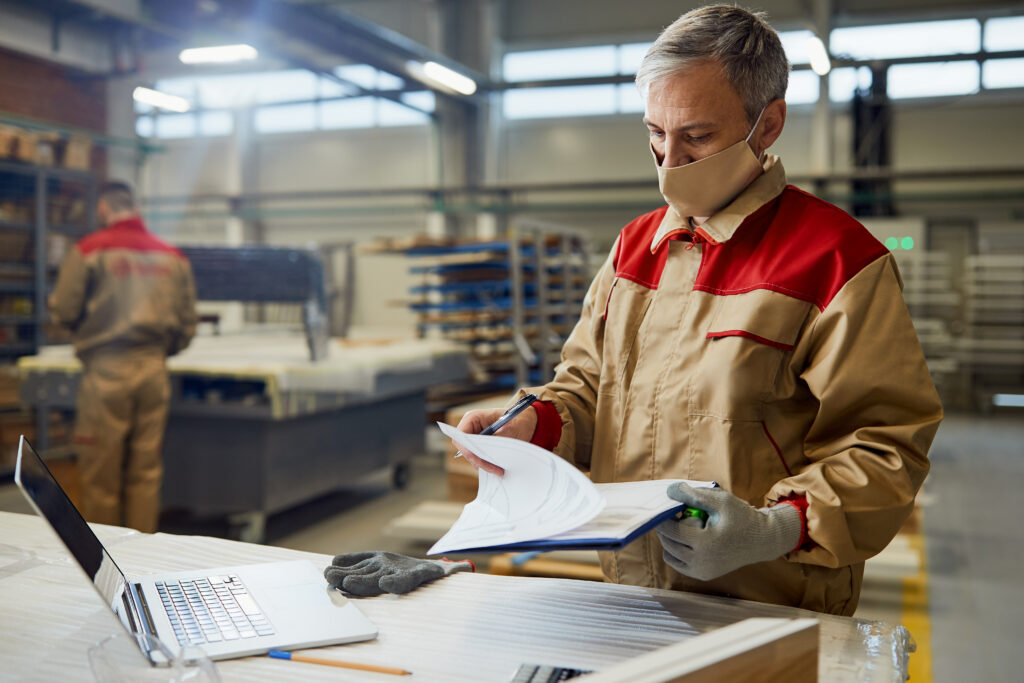 Artisan menuisier verifiant des documents et factures dans son atelier